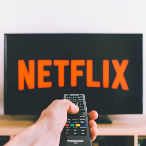 a TV remote pointing at a TV with Netflix displaying on it